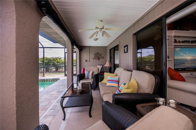 view of patio with outdoor lounge area, ceiling fan, and a lanai