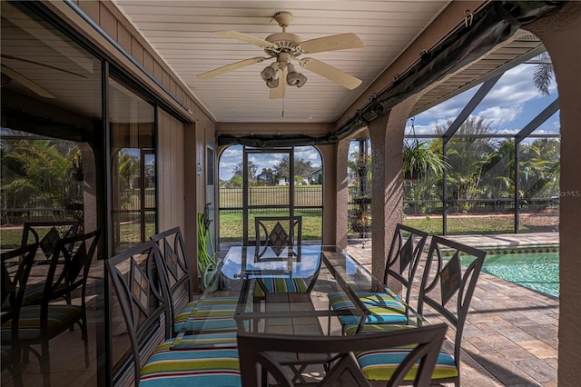 unfurnished sunroom with ceiling fan