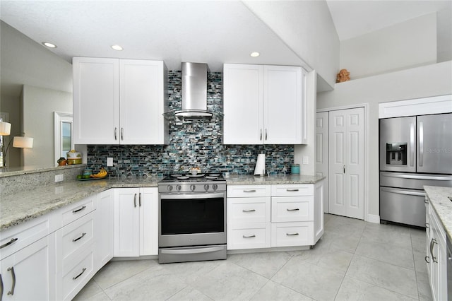 kitchen with stainless steel appliances, light stone countertops, wall chimney range hood, and white cabinets