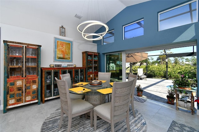 dining space featuring high vaulted ceiling