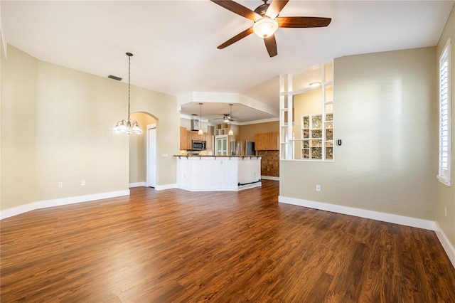 unfurnished living room with dark wood-type flooring and ceiling fan with notable chandelier