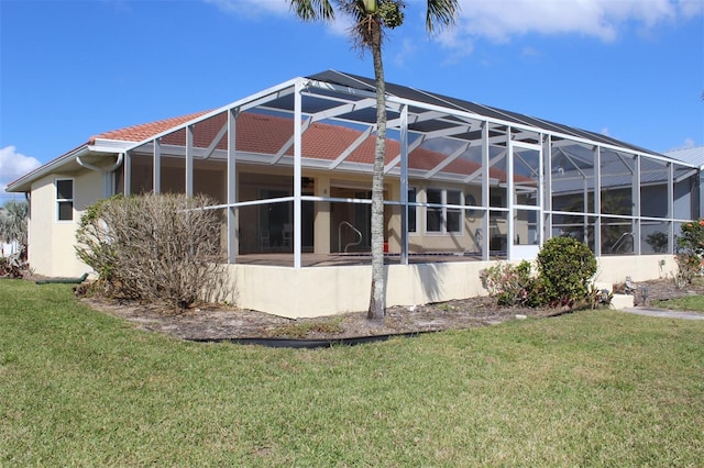 back of property featuring a patio, a lanai, and a lawn