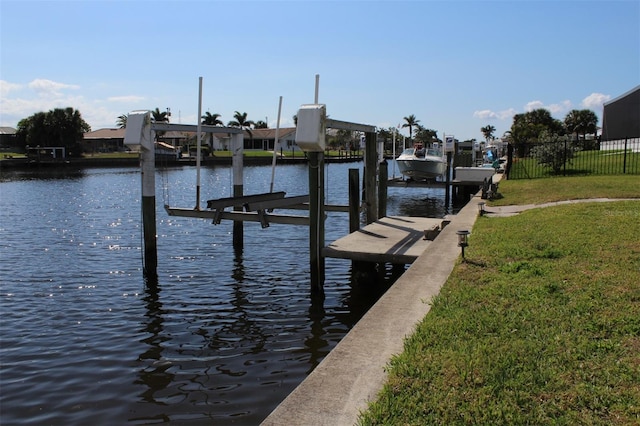 view of dock with a yard and a water view