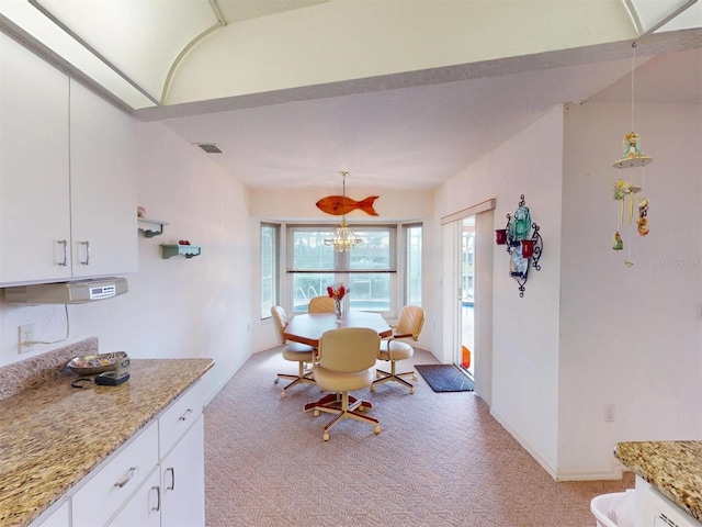 carpeted dining area featuring a chandelier