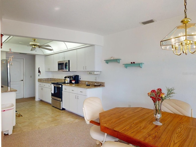 kitchen featuring pendant lighting, stone counters, white cabinetry, appliances with stainless steel finishes, and ceiling fan with notable chandelier