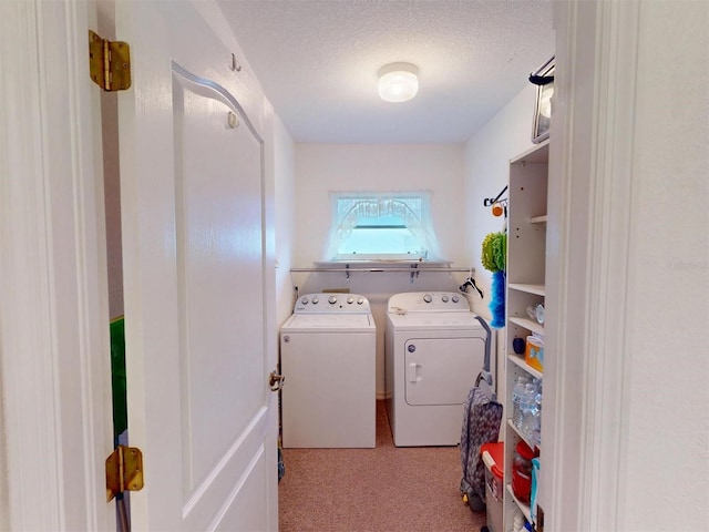 laundry room featuring washer and clothes dryer and a textured ceiling