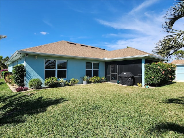 back of property with a yard and a sunroom