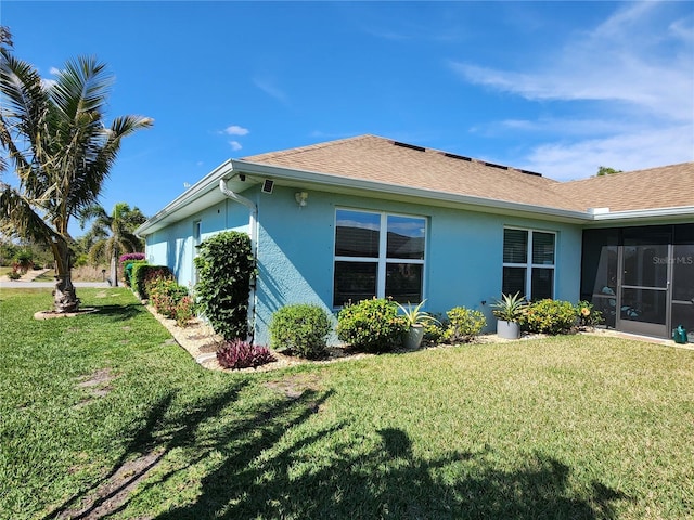 view of side of property with a lawn