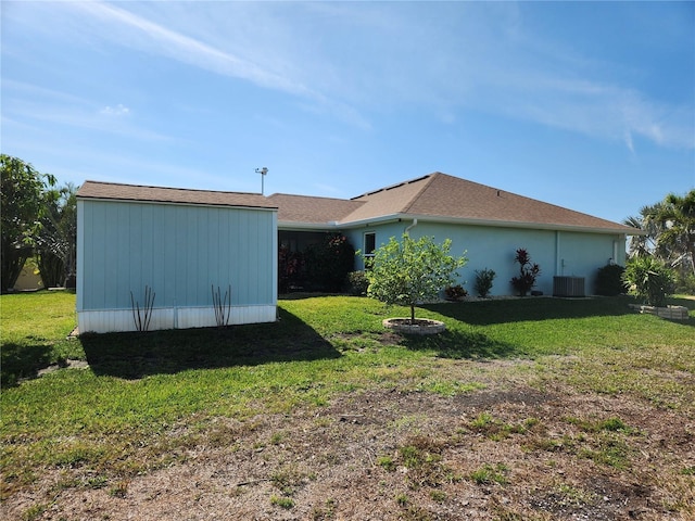 view of side of home featuring central AC unit and a lawn