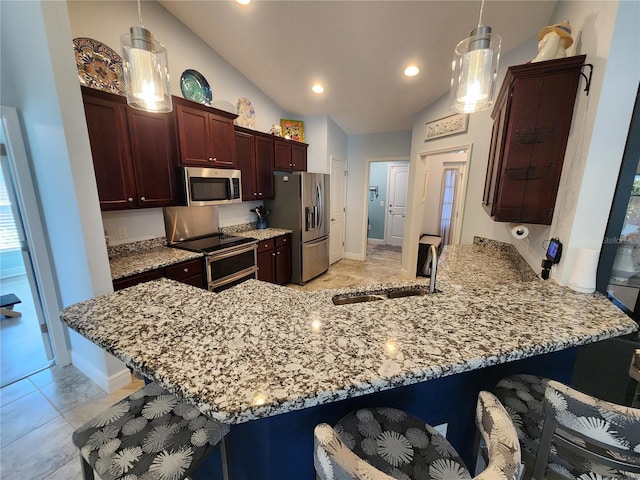 kitchen with pendant lighting, stainless steel appliances, kitchen peninsula, and sink