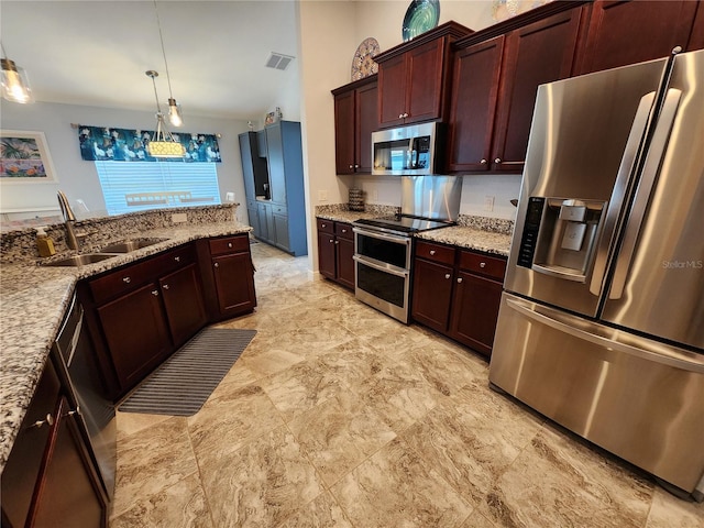 kitchen featuring light stone counters, sink, hanging light fixtures, and appliances with stainless steel finishes