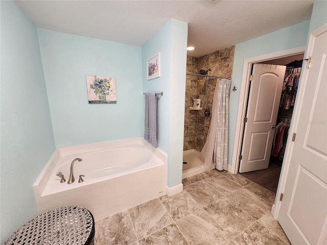 bathroom with separate shower and tub and a textured ceiling