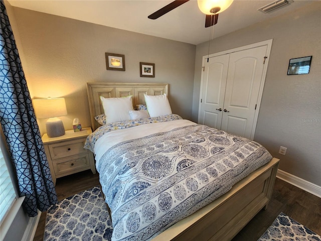 bedroom with a closet, dark hardwood / wood-style floors, and ceiling fan