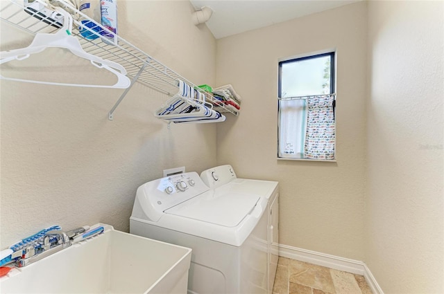 laundry area with separate washer and dryer and sink