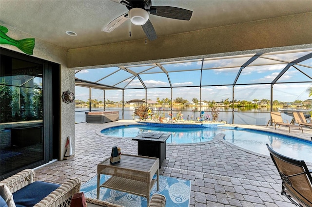 view of pool featuring a hot tub, a water view, glass enclosure, and a patio area