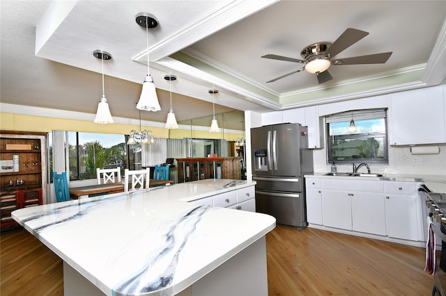 kitchen with stainless steel refrigerator with ice dispenser, a center island, and white cabinets