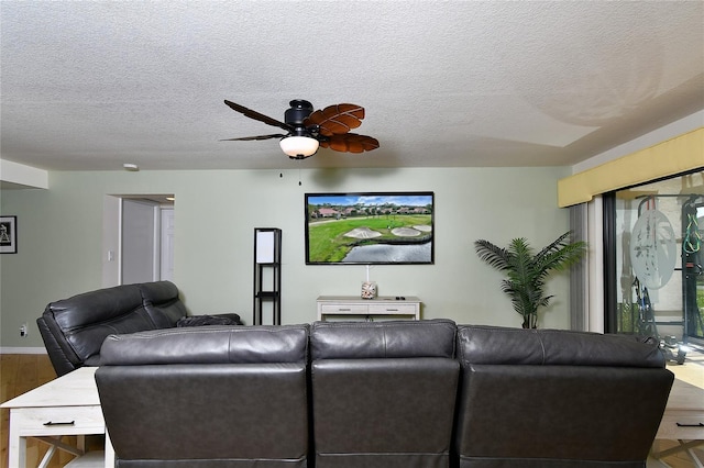 living room featuring ceiling fan, wood-type flooring, and a textured ceiling