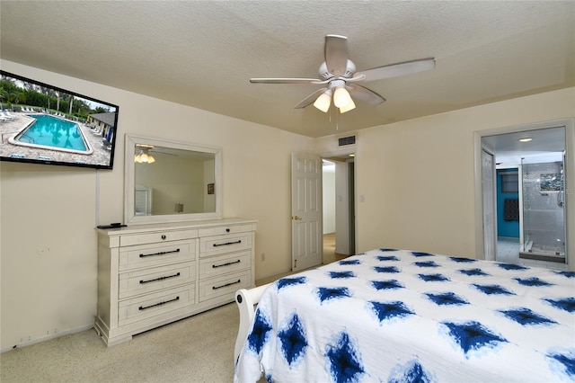 carpeted bedroom featuring ceiling fan, connected bathroom, and a textured ceiling