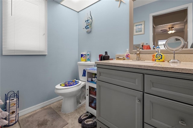 bathroom with tile patterned flooring, vanity, ceiling fan, and toilet