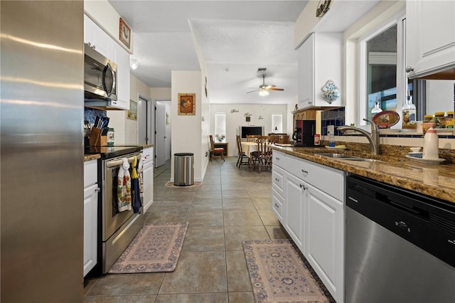 kitchen with dark stone countertops, sink, white cabinets, and appliances with stainless steel finishes