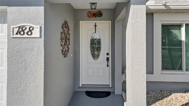 view of exterior entry with stucco siding