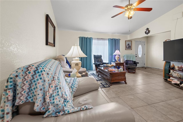 living room featuring tile patterned flooring, a ceiling fan, and vaulted ceiling