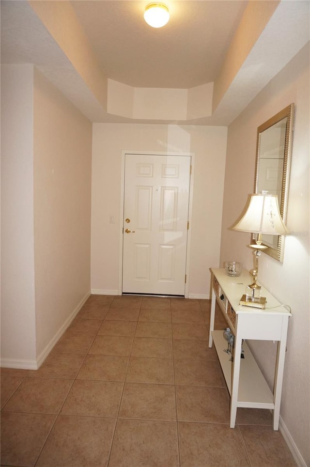 interior space featuring a raised ceiling and tile patterned flooring