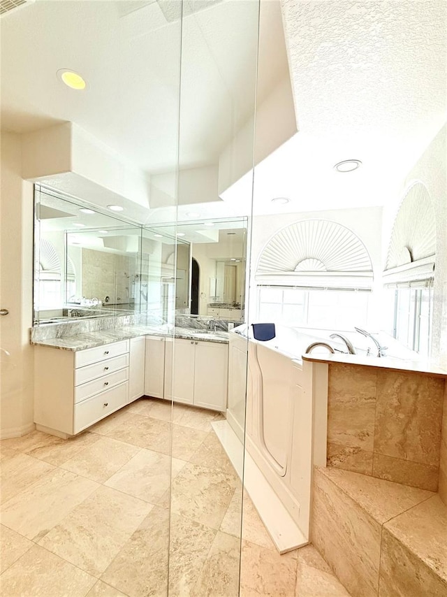 bathroom with vanity and a tub to relax in