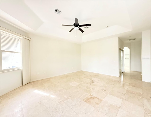 unfurnished room with a raised ceiling and ceiling fan