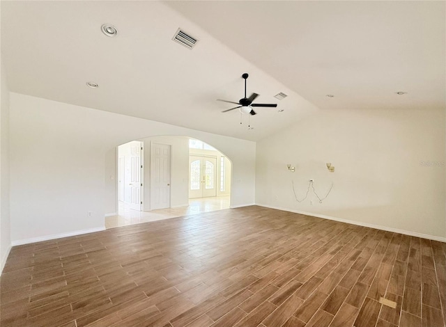 unfurnished room featuring french doors, ceiling fan, vaulted ceiling, and hardwood / wood-style flooring