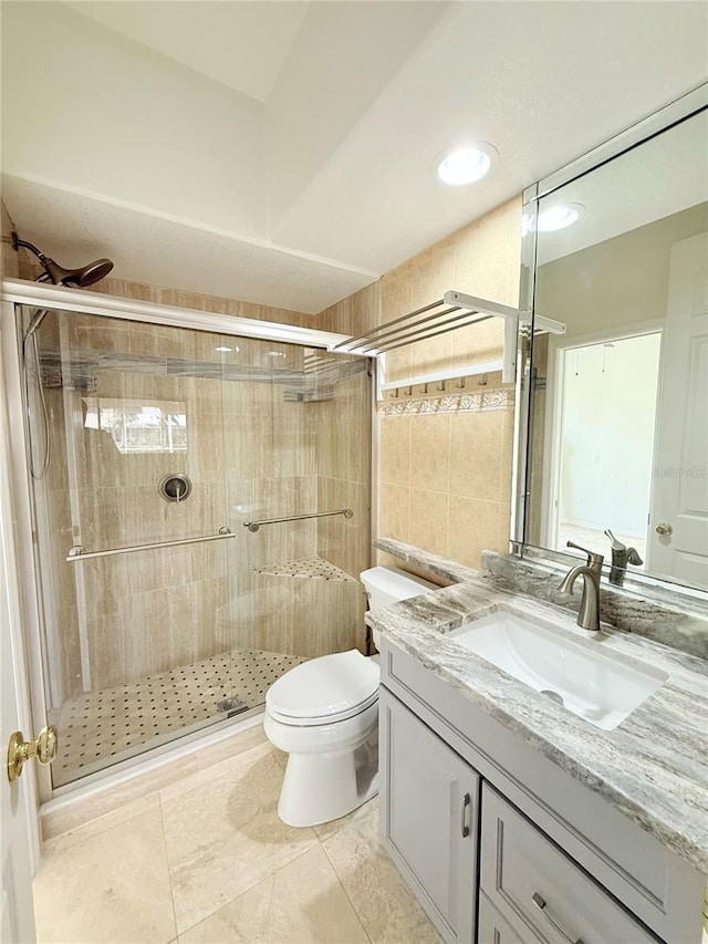 bathroom with vanity, toilet, tile patterned flooring, and a shower with door