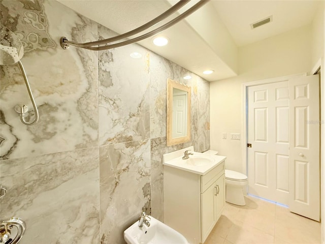 bathroom featuring vanity, walk in shower, toilet, a bidet, and tile patterned floors