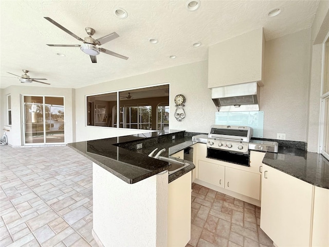 kitchen with sink, a textured ceiling, kitchen peninsula, custom range hood, and white cabinets