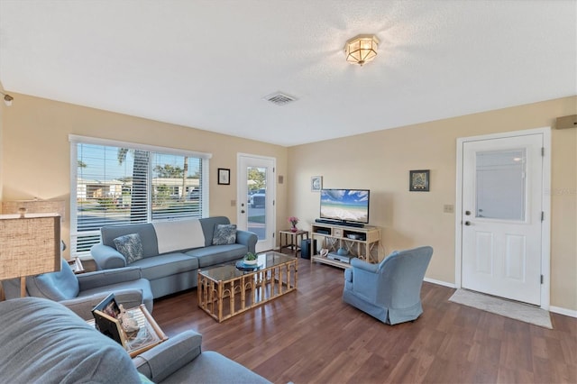 living room with dark hardwood / wood-style floors and a textured ceiling