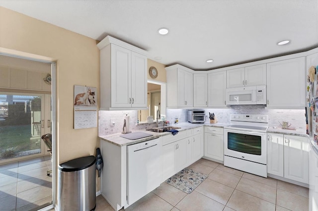 kitchen with sink, light tile patterned floors, white cabinets, white appliances, and backsplash