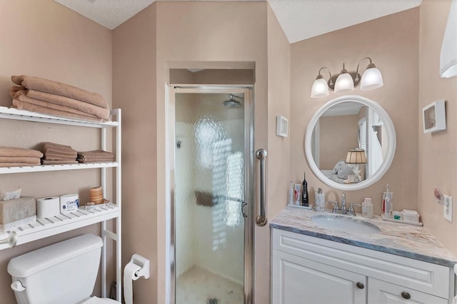 bathroom with vanity, toilet, an enclosed shower, and a textured ceiling