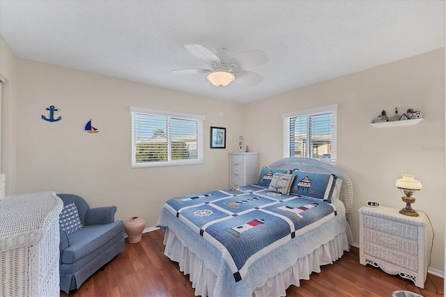 bedroom with ceiling fan, dark hardwood / wood-style flooring, multiple windows, and a textured ceiling