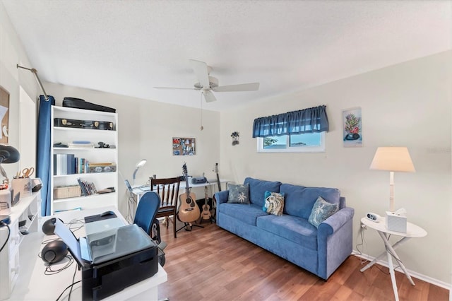 living room featuring ceiling fan, wood-type flooring, and a textured ceiling