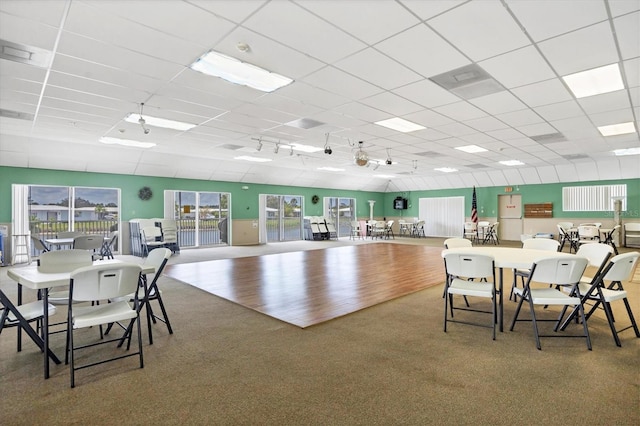 dining room with carpet, track lighting, and a drop ceiling