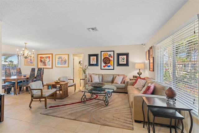 living room featuring light tile patterned floors, a textured ceiling, and a chandelier