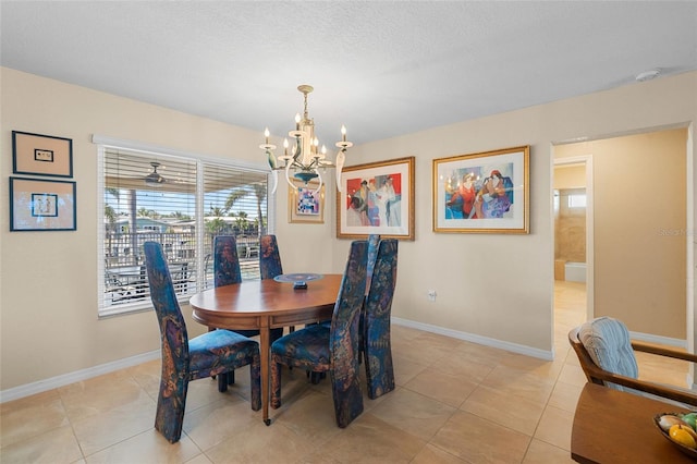 tiled dining space featuring a chandelier and a textured ceiling