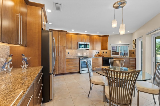 kitchen with sink, appliances with stainless steel finishes, backsplash, hanging light fixtures, and light stone counters