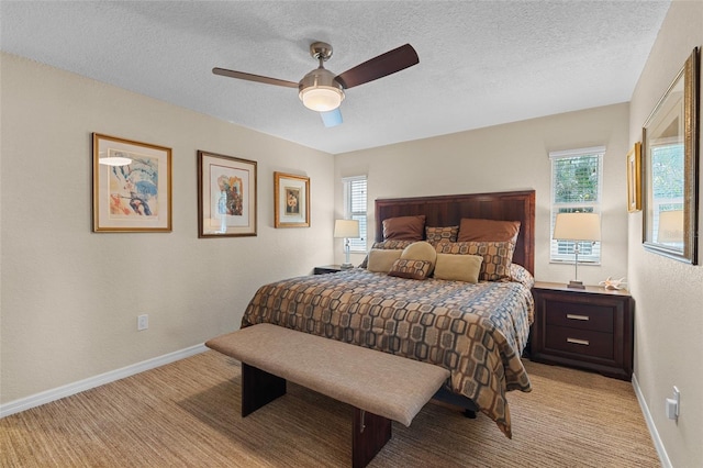 carpeted bedroom with ceiling fan and a textured ceiling