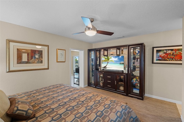 bedroom featuring ceiling fan, access to exterior, and a textured ceiling