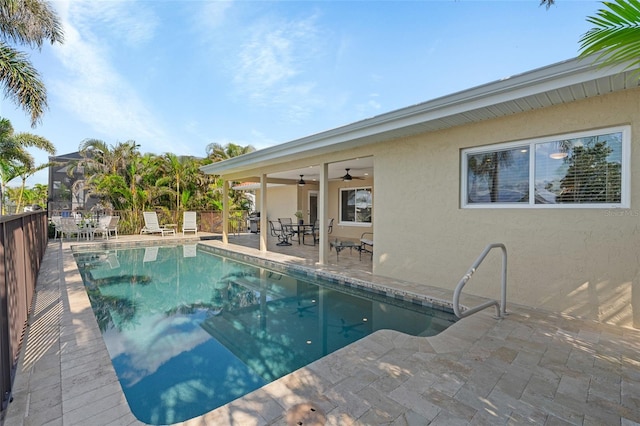 view of pool with a patio, ceiling fan, and glass enclosure