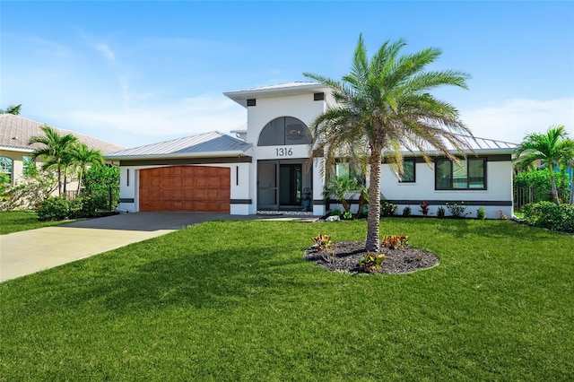 view of front of house with stucco siding, an attached garage, a standing seam roof, metal roof, and driveway