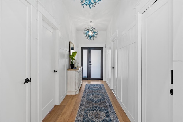 doorway featuring a chandelier and light wood-style flooring