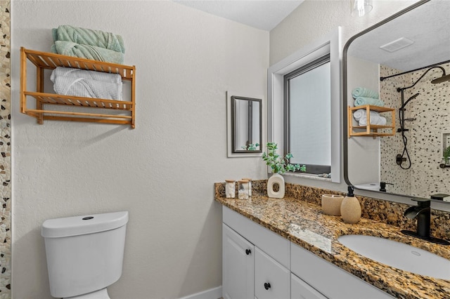 bathroom with a shower, visible vents, a textured wall, toilet, and vanity