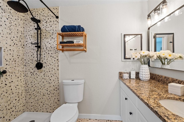 full bath featuring vanity, a shower stall, toilet, and baseboards