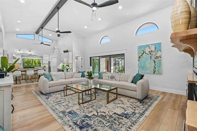 living room with beam ceiling, light wood-type flooring, a fireplace, and a ceiling fan